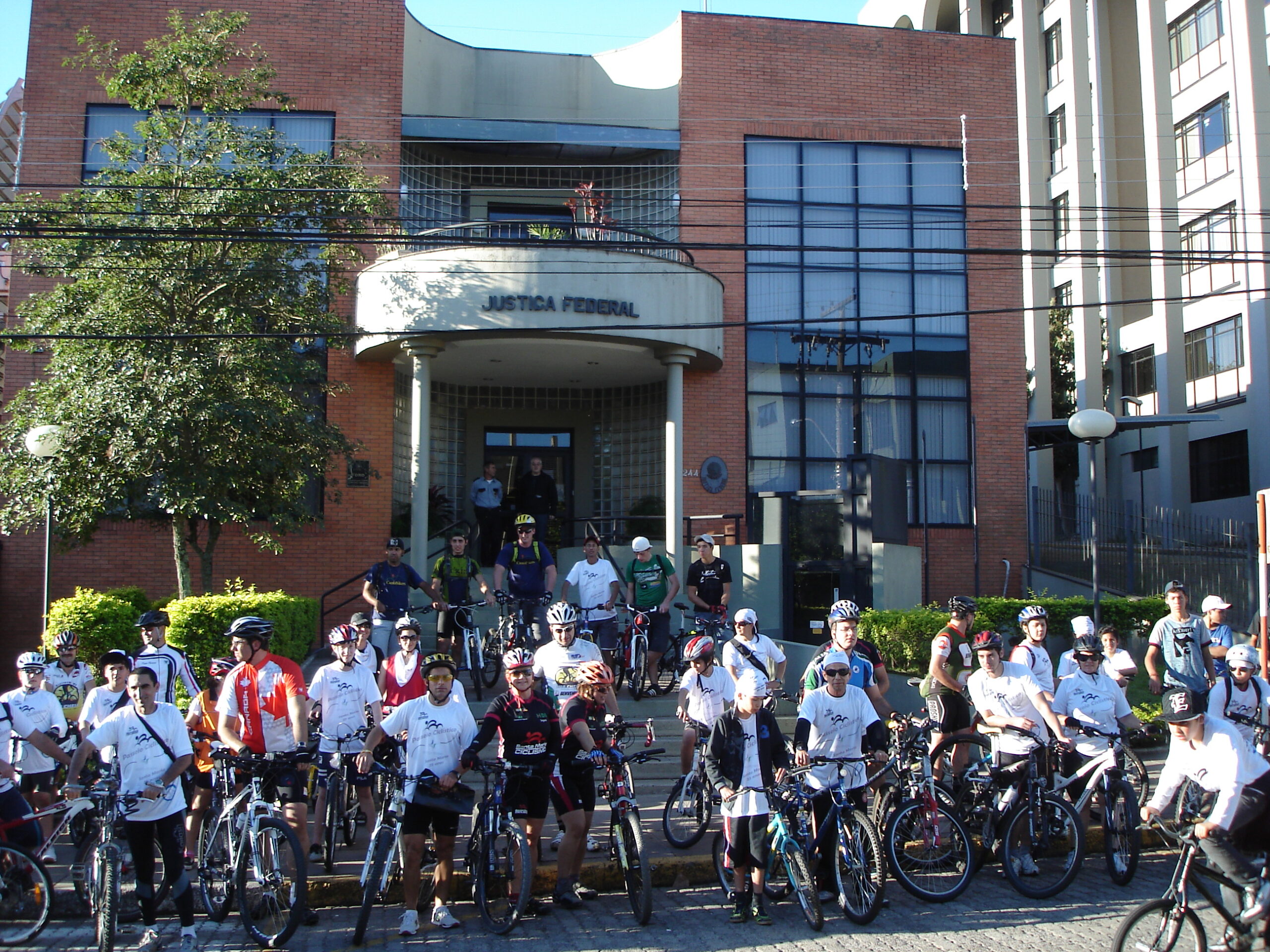 a foto mostra diversas ciclistas em frente ao prédio da justiça federal