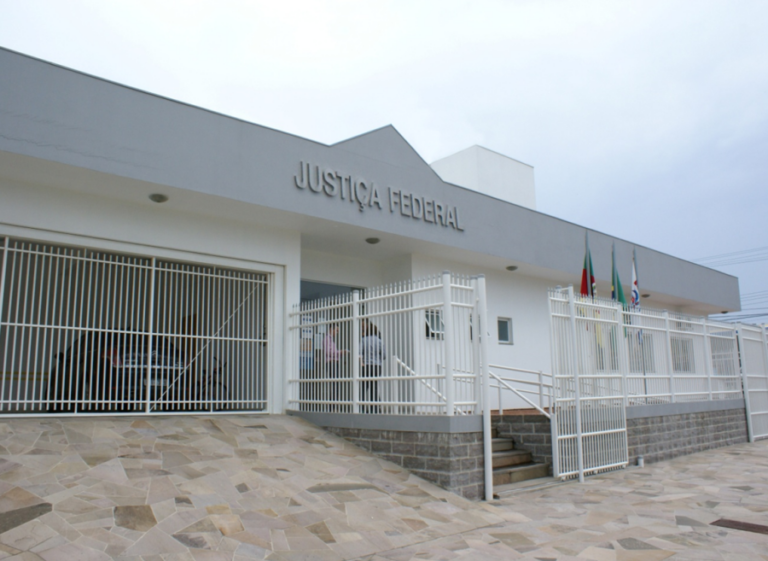 a foto mostra a fachada da sede, construção de piso térreo, branca, que tem a inscrição justiça federal